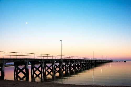 Jetty leading off into ocean at sunrise - Australian Stock Image