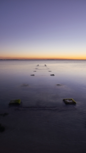 Jetty ruins at dusk in the ocean long exposure. - Australian Stock Image