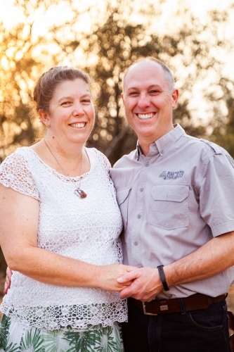 Joyful middle aged couple standing together in afternoon light - faithfulness - Australian Stock Image