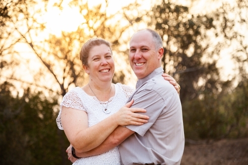 Joyful middle aged couple standing together in afternoon light - faithfulness - Australian Stock Image