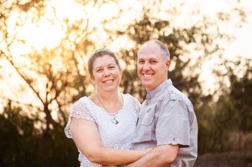 Joyful middle aged couple standing together in afternoon light - faithfulness - Australian Stock Image