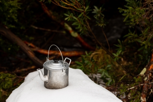 Kettle on a snowy mound in a forest