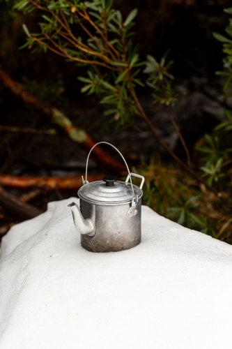 Kettle on a snowy mound in a forest - Australian Stock Image