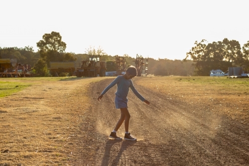 kid dancing in the dirt on a farm - Australian Stock Image