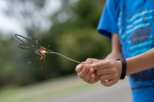 Kid playing with sparklers on New Years Eve - Australian Stock Image