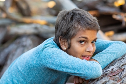 kid resting chin on her arms in the bush - Australian Stock Image