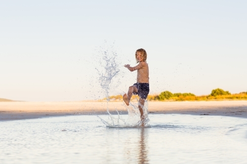 Kid splashing water on the beach