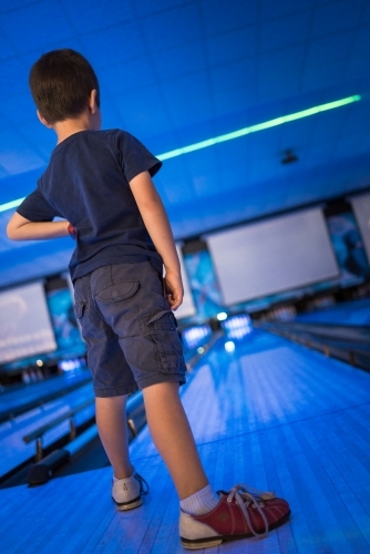 Kids 10 pin bowling under blue lights - Australian Stock Image