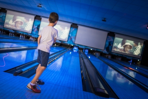 Kids 10 pin bowling under blue lights - Australian Stock Image