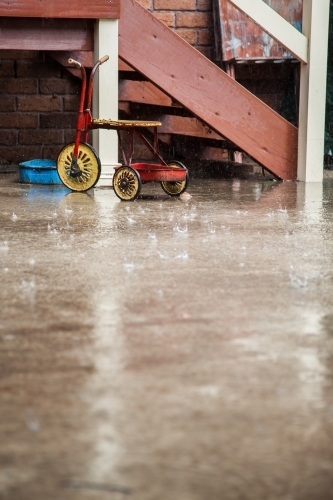 Kids bikes and toys left outside in the rain - Australian Stock Image