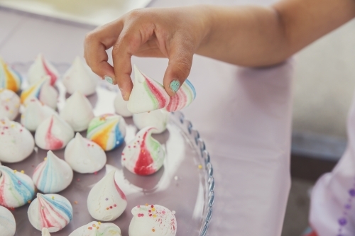 Kids hand picking meringue drops - Australian Stock Image