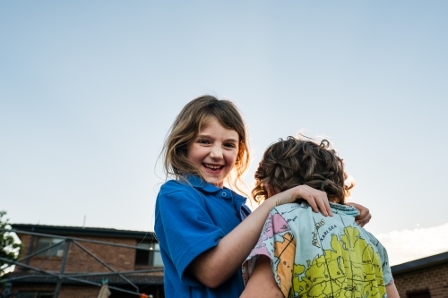 Kids playing in backyard at sunset