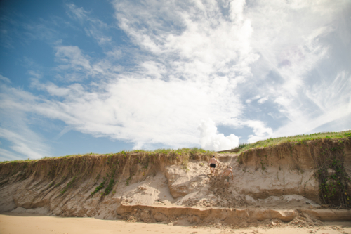 Kids playing on the sand dunes at the beach, Coffs Harbour Australia - Australian Stock Image