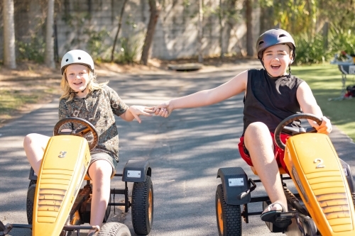 Kids riding pedal carts on family holiday at a caravan park - Australian Stock Image