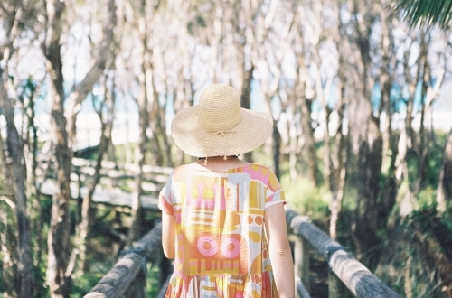 Lady in pastel walking toward the beach