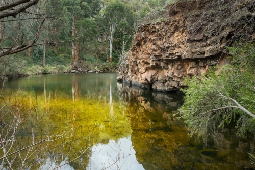 Lagoon and volcanic rock central Victoria quiet scene of billabong water and rock - Australian Stock Image