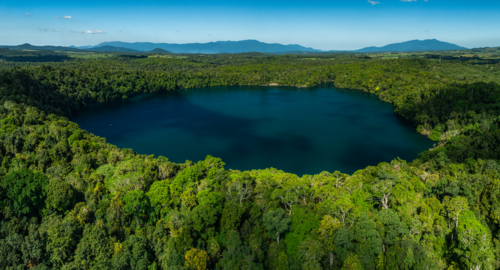 landscape of rainforest and deep blue lake - Australian Stock Image