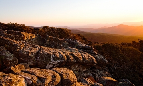 Landscape of rocks and mountain range at sunset