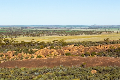 landscape view of rocks, bush and farmland in the wheatbelt