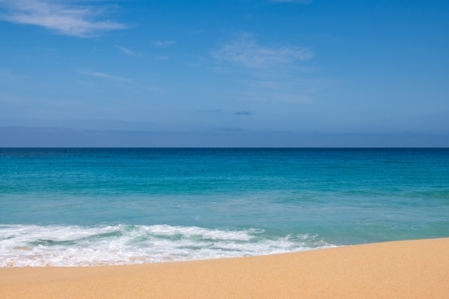 Landscape view of sand and ocean, and blue sky