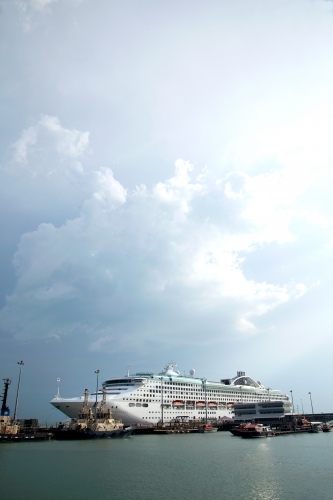 Large cruise liner docked at an industrial port - Australian Stock Image