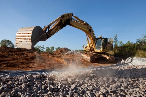 Large digger moving rocks on an industrial building site - Australian Stock Image