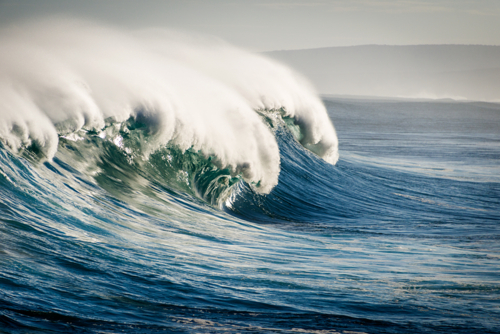Large ocean wave curling with mist blowing off the crest - Australian Stock Image