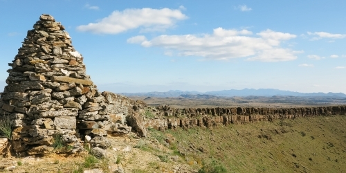 Large rock cairn with stunning rocky landscape in background - Australian Stock Image