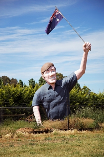 Large sculpture of man holding an Australian flag in a field - Australian Stock Image