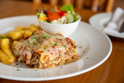 lasagne chips and salad sitting on table - Australian Stock Image