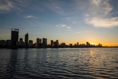 Last light setting behind Swan River and Perth city skyline - Australian Stock Image