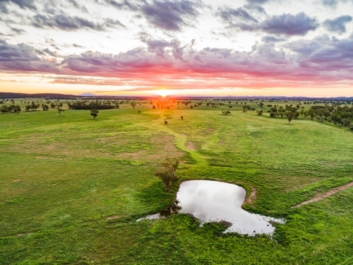 Last rays of sunlight over farmland and dam - Australian Stock Image