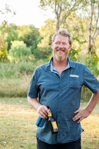 Laughing man with two beer bottles in the park - Australian Stock Image