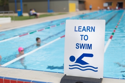 Learn to swim sign at a swimming pool