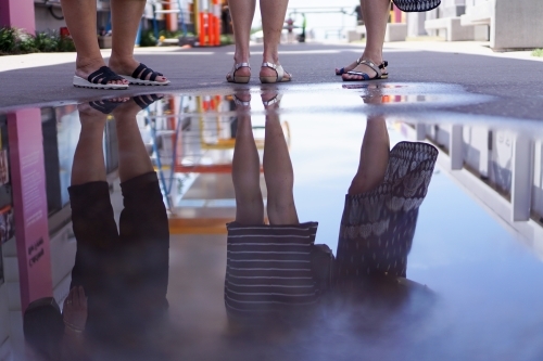 Leg reflections in a puddle of water - Australian Stock Image