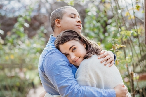 lgbtqi couple hugging each other and being cozy outside - Australian Stock Image