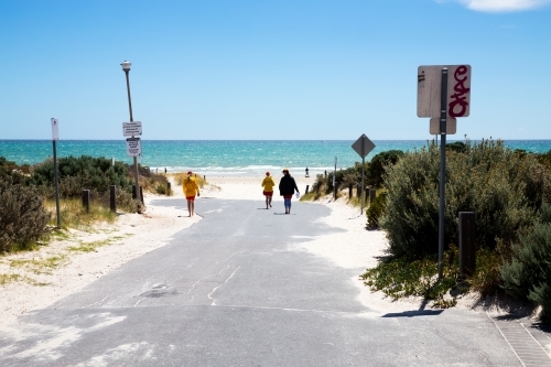 Lifesavers walking down to beach along access road - Australian Stock Image