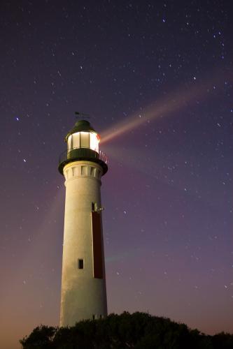 Light beams from a lighthouse at night - Australian Stock Image