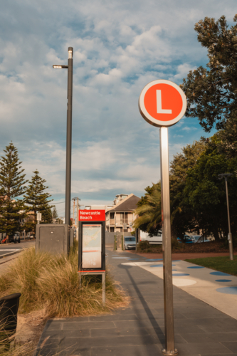Light rail stop at Newcastle Beach with red L sign - Australian Stock Image