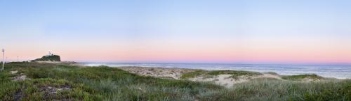 Lighthouse and grass covered sand dunes at dusk - Australian Stock Image