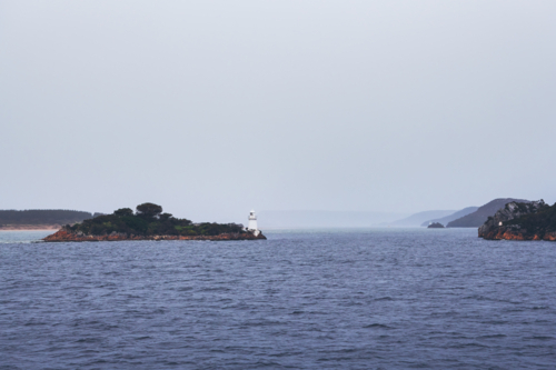 Lighthouse on island in harbour entrance, Tasmania - Australian Stock Image