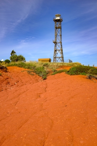 Lighthouse tower surrounded by red dirt and blue sky - Australian Stock Image