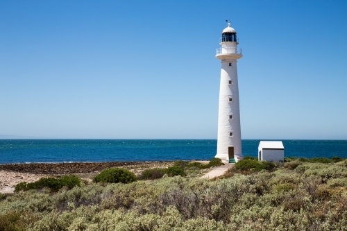 lighthouse with blue water and cloudless sky - Australian Stock Image