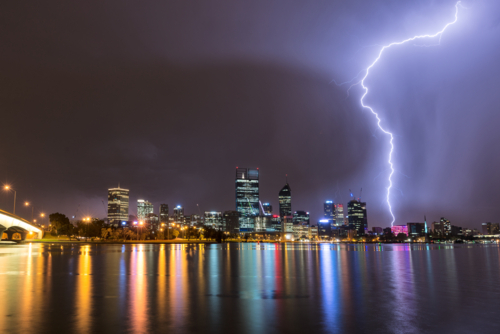 Lightning Over Perth City And Swan River with lights reflected in water - Australian Stock Image