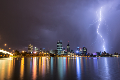 Lightning Over Perth City And Swan River with lights reflected in water - Australian Stock Image