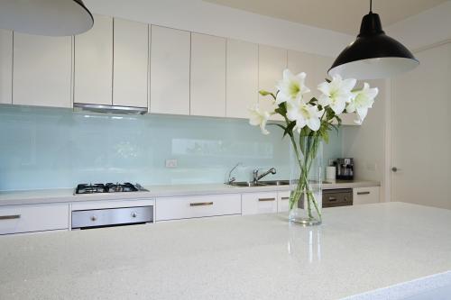 Lily flowers on white kitchen island bench top - Australian Stock Image