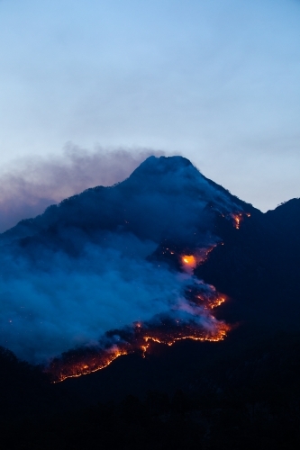 Line of fire crossing a mountain range at dusk - Australian Stock Image
