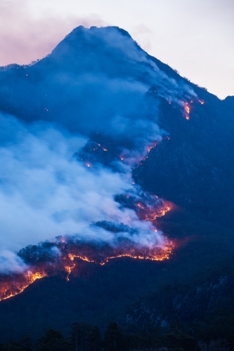 Line of fire crossing a mountain range at dusk - Australian Stock Image
