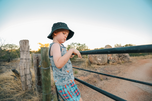 Little boy climbing rustic farm gate in rural Victoria - Australian Stock Image