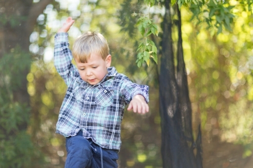 Little boy in checked shirt playing outdoors